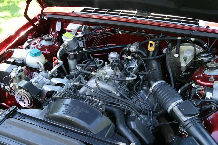 Open engine bay showing hoses, belts and the intake