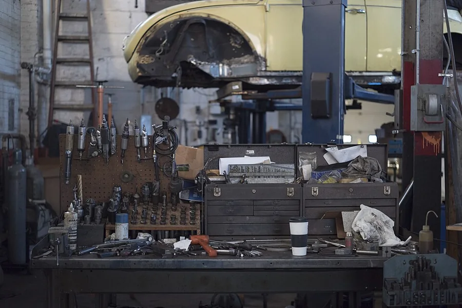 Mechanic workbench with tools and a car on a lift